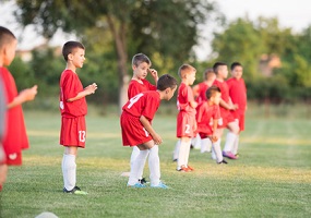 Kids soccer football - small children players exercising before match on soccer field